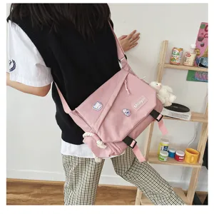 Japanese Harajuku pink messenger bag for students, casual canvas crossbody bag with cute pins.
