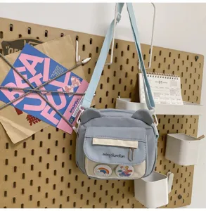 Niedliche blaue Umhängetasche mit Bärenohren im Kawaii-Stil, Detailansicht der Schultasche.