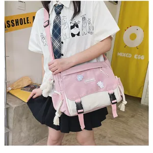 Close-up shot showing the pink and white student messenger bag details, cute bear pendant.