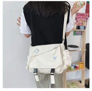Detailed view of casual white canvas messenger bag with cute bear pendant and spacious design.