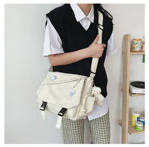 Detail shot of Japanese casual student messenger bag, large capacity crossbody bag with cute charm.