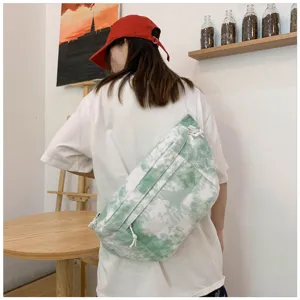 Borsa a tracolla in tela tie-dye verde in ambientazione, borsa casual da studente per tutti i giorni.