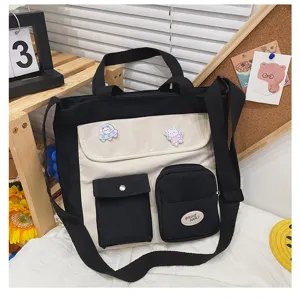 Detailed view of the black and white canvas tote bag, featuring multi-pockets and cute badges.