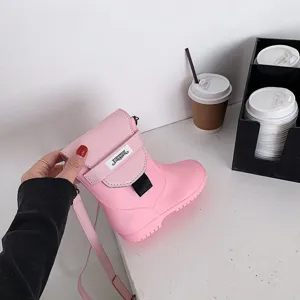 Gros plan d'un sac à bandoulière rose unique en forme de chaussure avec un design créatif.