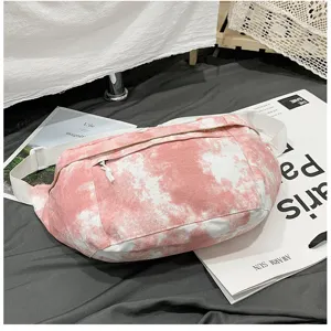 Dettaglio della borsa a tracolla in tela tie-dye rosa e bianca con tasca con zip e cinghia.