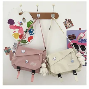 Japanese Harajuku style canvas messenger bag detail showing cute bear pendants and dual buckle.