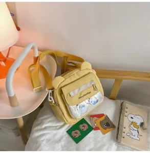 Detailansicht der gelben Bär-Leinen-Umhängetasche mit transparenter Tasche und süßen Ohren.
