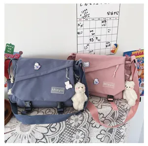 Detailed view of casual canvas messenger bag with cute bear pendant and large capacity.