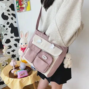 Korean style canvas crossbody bag with multi-pockets and cute bear pendant for students.