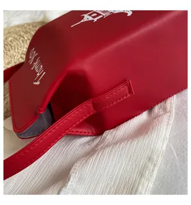 Dettaglio borsa a tracolla in ecopelle rossa, con stampa pagoda cinese e cinturino coordinato.