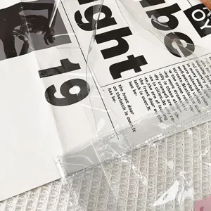 Klares transparentes Umhängetasche Detail mit PVC Material und Zeitungsmuster Einlage.