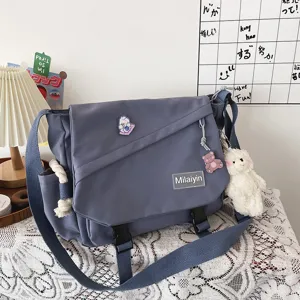 Detailed view of the casual canvas messenger bag with cute pendant and large storage capacity.