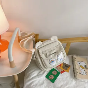 Niedliche Umhängetasche mit Bärenohren im Detail, weiße weiche Schultasche mit transparenter Tasche.