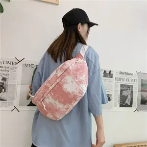 Vista dettagliata della borsa a tracolla in tela tie-dye rosa, design streetwear elegante.