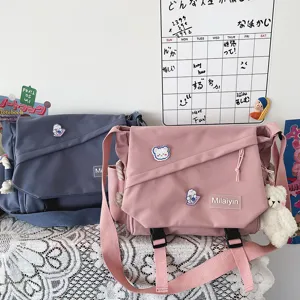 Detailed view of Japanese Harajuku style canvas messenger bag with large capacity and cute pins.