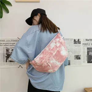 Vista dettagliata della borsa a tracolla in tela tie-dye rosa indossata, capiente e pratica.