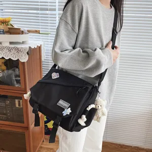 Detail view of casual black canvas messenger bag, stylish daily student crossbody bag style.