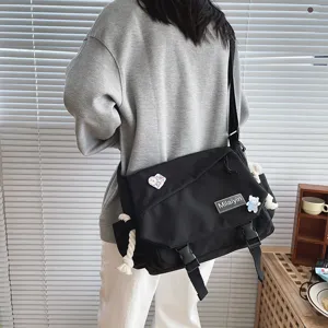 Detailed view of the casual canvas messenger bag with buckle closure and cute badge.