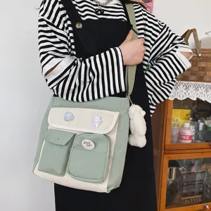 Detail shot of the contrast color canvas crossbody bag, featuring front pockets and cute strap.