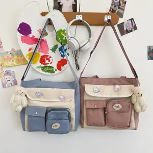 Detailed shot of cute multi-pocket canvas crossbody bag with bear pendant and vintage aesthetic.