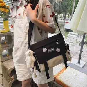 Detail shot of Japanese style canvas messenger bag with contrast color and cute plush bear.