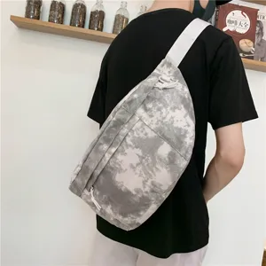 Vista dettagliata di una elegante borsa a tracolla in tela tie-dye grigia indossata.