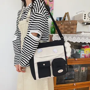 Casual canvas crossbody bag with contrast color design, multiple pockets, and cute pins.