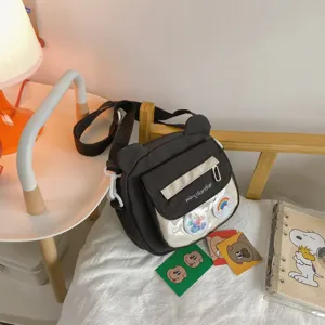 Detailaufnahme der braunen Bären-Umhängetasche mit transparenter Tasche und verstellbarem Gurt.