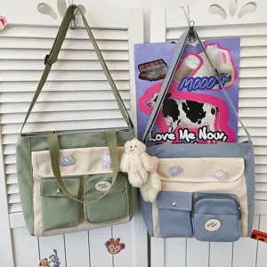 Close-up detail of multi-pocket canvas shoulder bags with cute pendant and patches.