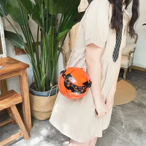 Halloween pumpkin crossbody bag with chunky black acrylic chain and creative novelty design.