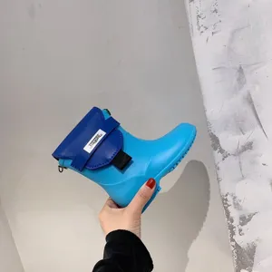 Vue détaillée d'un sac bandoulière novateur en forme de botte bleue à rabat contrasté.