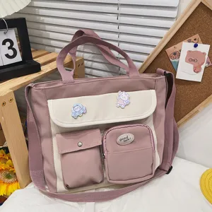 Detailed view of stylish pink canvas crossbody bag featuring multi pockets and cute badges.
