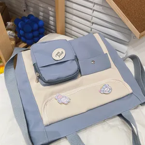 Canvas shoulder bag detail showing blue and white color block design with cute badges and pockets.