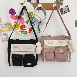 Canvas cross-body bag detail, stylish two-tone design with cute pockets and charms.