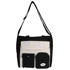 Canvas crossbody bag detail showing black white color block and front pockets with cute pins.