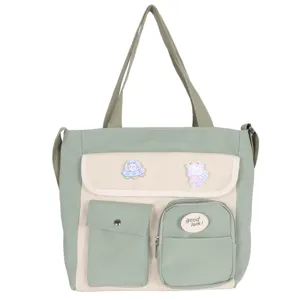 Detail view of canvas crossbody bag with multi pockets cute patches green beige design.