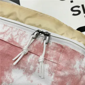 Primo piano dettagliato della borsa in tela con cerniera lampo e tiranti in corda.