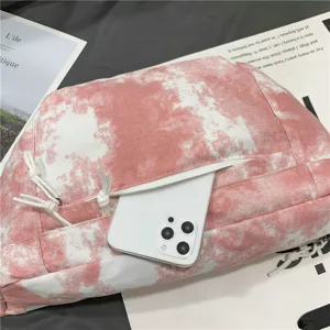 Primo piano della tasca di dettaglio della borsa a tracolla in tela tie-dye rosa bianco.