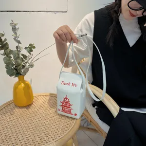 Primo piano della borsa a tracolla in PU bianco a forma di cartone di latte con stampa.