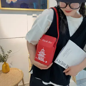 Primo piano dettagliato di una borsa a tracolla creativa in PU rosso cartone latte.