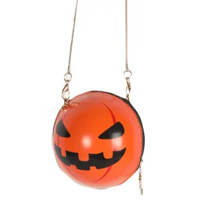 Closeup of Halloween pumpkin round crossbody bag with gold chain, unique festival accessory.