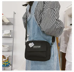 Bolso cruzado de lona negra vista detallada, bolso de hombro casual con bolsillo delantero.