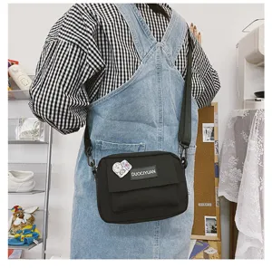 Estiloso bolso bandolera informal de lona negra para mujer, bolso cruzado con correa.