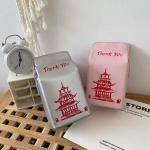 Vista dettagliata di borse a tracolla creative a forma di cartone del latte argento e rosa, pagoda.