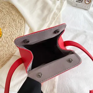 Dettaglio borsa a tracolla pagoda in pelle PU rossa, forma unica con chiusura a clip.