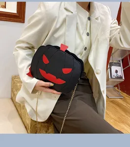 Closeup detail of black PU leather Halloween pumpkin crossbody bag with red devil face design.