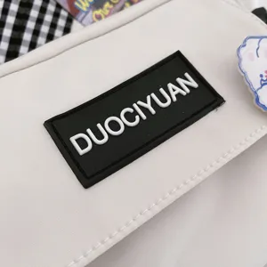 Primer plano detallado de bolso bandolera de lona estilo Harajuku con parche de logotipo de goma.