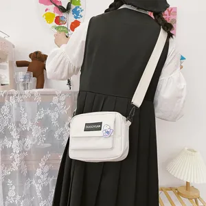 Bolso bandolera de lona blanca con parche delantero y pegatina, estilo Harajuku.