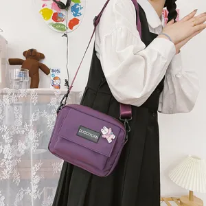 Vista detallada de un bolso cruzado morado de estilo Harajuku japonés llevado por modelo.