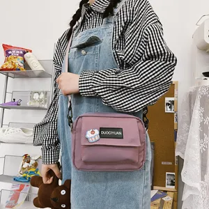 Vista detallada del bolso cruzado de lona Harajuku japonés con parche lindo y correa ajustable.